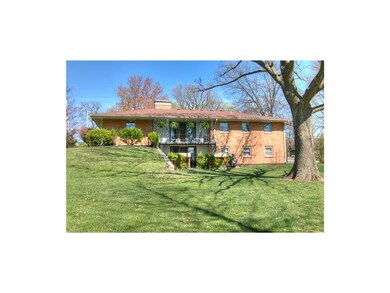 Back view of home with balcony overlooking the lar