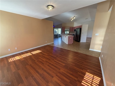 Unfurnished living room featuring lofted ceiling a