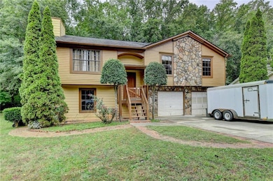 Bi-level home with stone siding, a chimney, concre