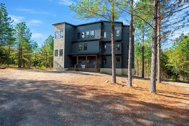 Back of property featuring covered porch and stone siding
