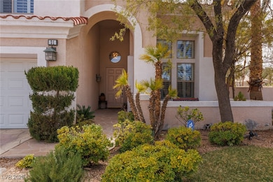 Entrance to property featuring a garage and stucco