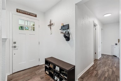 Foyer entrance with wood finished floors and baseboards