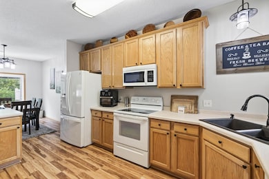 This gourmet kitchen has it all! An abundance of cabinets above and below, counter space and then some, large pantry, extra deep fridge and freezer with pull out extension and all white appliances that add to the bright, open concept.