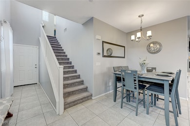 Dining area featuring a chandelier, stairs, basebo