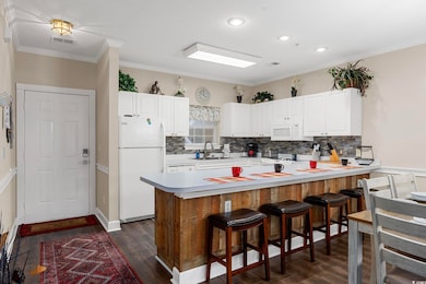 Kitchen with white cabinetry, white appliances, a 
