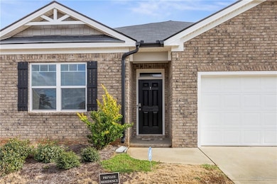 Entrance to property with brick siding, a garage, 