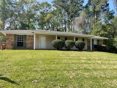 Ranch-style house with a front lawn and brick sidi