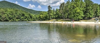 Water view featuring a wooded view and a mountain 