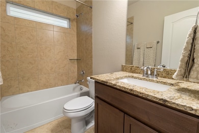 Full bathroom with a textured wall, tile patterned