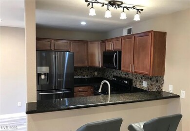 Kitchen with black appliances, backsplash, dark stone counters, and a peninsula