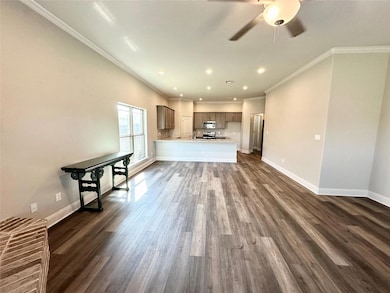 Living room featuring ceiling fan, ornamental molding and luxury vinyl plank flooring