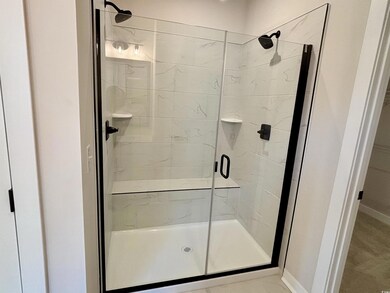 Bathroom with a stall shower and baseboards