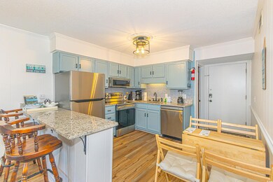 Kitchen featuring a peninsula, a sink, appliances with stainless steel finishes, a kitchen breakfast bar, and light wood-type flooring