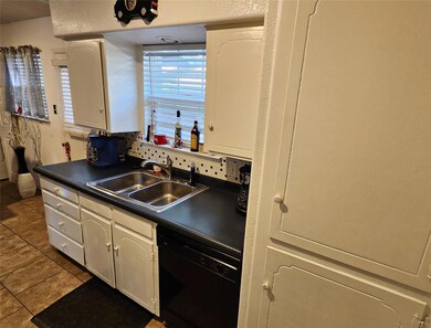Kitchen featuring tile patterned floors, dark coun
