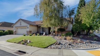 View of front of property with stucco siding, an attached garage, a front lawn, driveway, and a tile roof