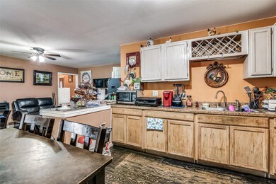 Kitchen featuring a ceiling fan, open floor plan, 