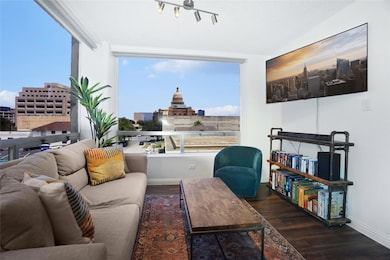Living area with dark wood-style flooring and a desk