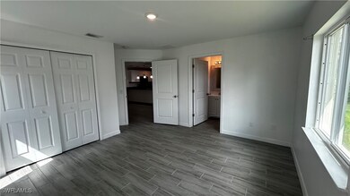 Unfurnished bedroom featuring hardwood / wood-style floors, a closet, and ensuite bath