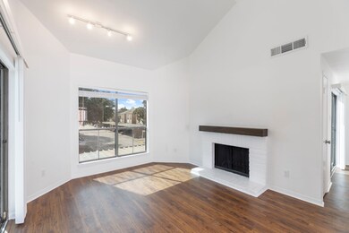The rich, earthy tones of the laminate flooring with the updated wood mantel is a beautiful focal point.
