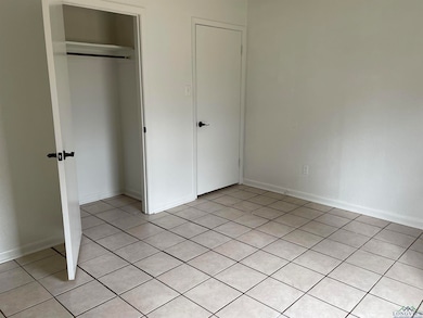 Unfurnished bedroom with light tile patterned floo