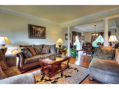 Elegant formal living room featuring crown mouldin