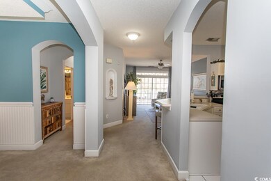 Corridor featuring wainscoting, light colored carp