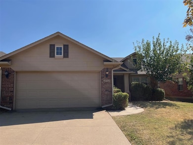 Single story home with a garage and a front lawn