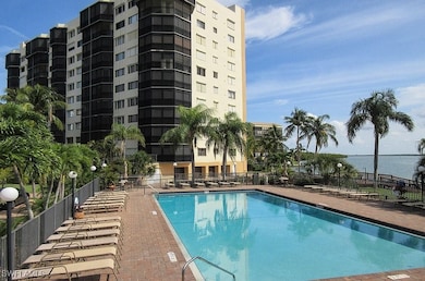 Pool with a water view, a patio, and fence