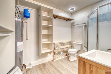 Bathroom featuring wood finished floors, a shower stall, and vanity