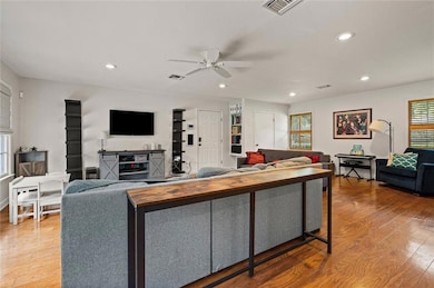 Living area featuring hardwood / wood-style flooring, ceiling fan, and recessed lighting