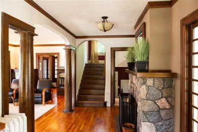 Hardwood floored foyer entrance with a textured ceiling, radiator, and ornamental molding
