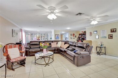Living room featuring ceiling fan, ornamental mold