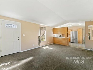 Unfurnished living room featuring vaulted ceiling and light colored carpet