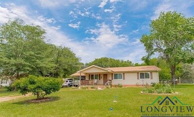 Ranch-style house featuring covered porch and a front yard