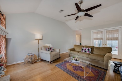 Living area featuring vaulted ceiling, french doors, and light wood finished floors