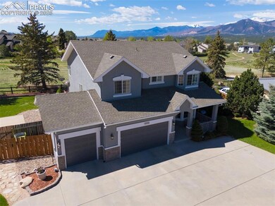 View of front of home featuring stucco siding, a mountain view, driveway, and stone siding