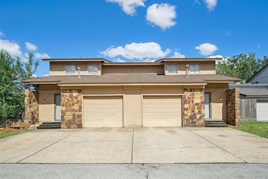 View of front facade with stone siding, driveway, 