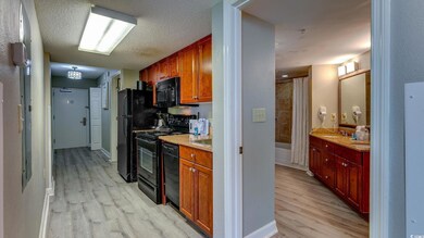 Kitchen with black appliances, sink, light stone c