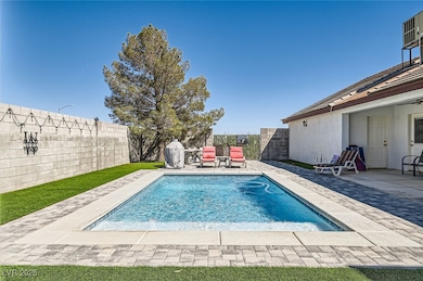 View of pool with a fenced backyard, a patio area,