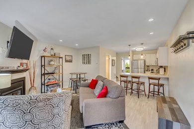 Living room featuring a fireplace, light wood-style flooring, and recessed lighting