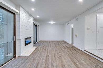 Unfurnished living room featuring light wood-style flooring, recessed lighting, and a large fireplace