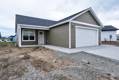 Ranch-style home featuring roof with shingles, an attached garage, and driveway