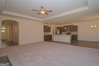 Unfurnished living room with arched walkways, a ra