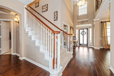 Two story entry hall showing the beautiful engineered wood floors throughout the first floor living areas, study and hallway.