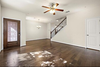 Unfurnished living room with a chandelier, dark wood-type flooring, ceiling fan, and stairway