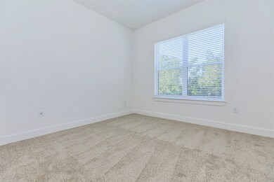 Spacious primary bedroom with large window