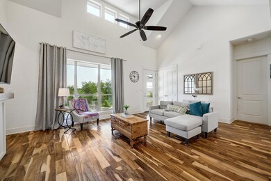 Living area featuring high vaulted ceiling, hardw