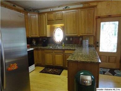 Kitchen has raised oak cabinetry, granite counters