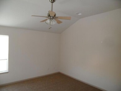 Master bedroom with vaulted ceiling and fan.