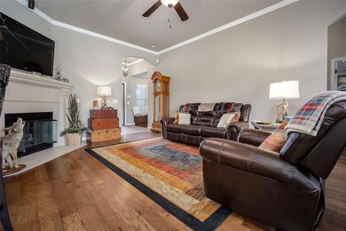 Living room with crown molding, a tiled fireplace,
